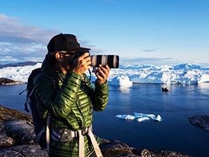 A man using his DSLR camera in icy terrain
